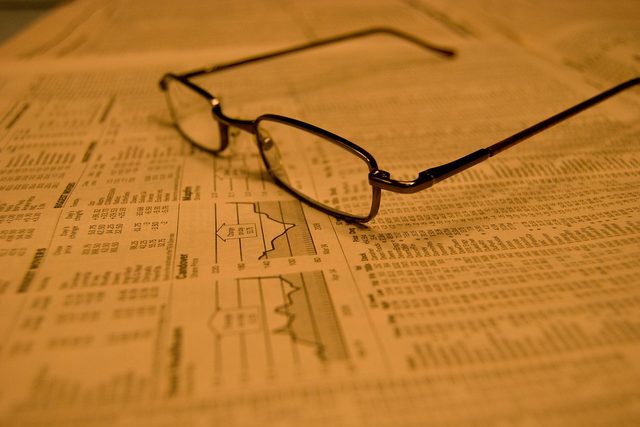 Quotidiano economico e occhiali da lettura, leggere i mercati
